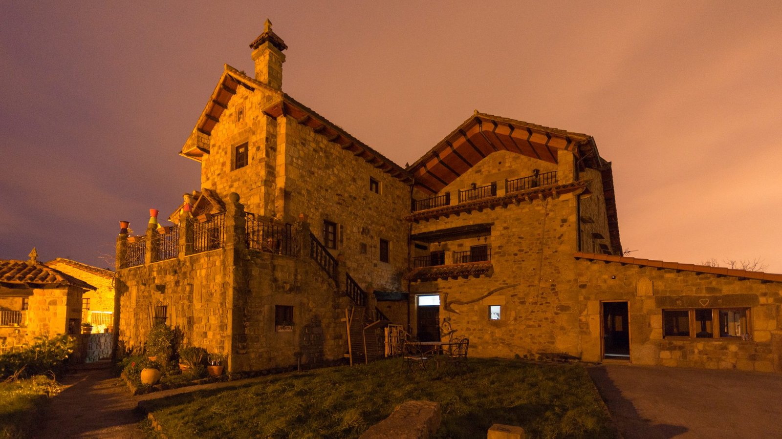 Mesa con vino Rioja Crianza, tabla de quesos artesanos y embutidos junto a ventana con vistas al pueblo